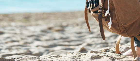 Barfuß mit Rucksack am Strand